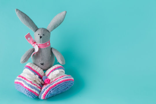 Funny bunny in baby booties on aquamarine background