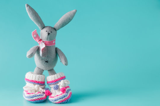 Funny bunny in baby booties on aquamarine background