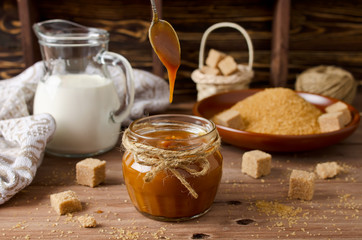 Homemade caramel sauce on wooden table
