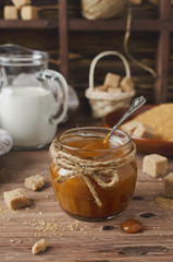Homemade caramel sauce on wooden table