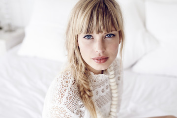 Portrait of young blond woman in white