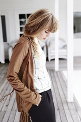 Young blond woman posing on porch, looking down