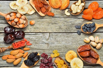 Mix of dried fruits and nuts on a wooden table - symbols of judaic holiday Tu Bishvat. Copyspace background.Top view.