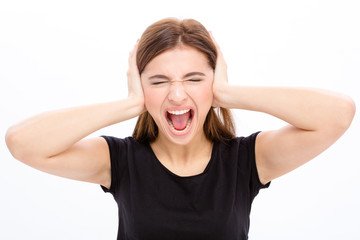 Angry irritated young woman covered ears by hands and shouting