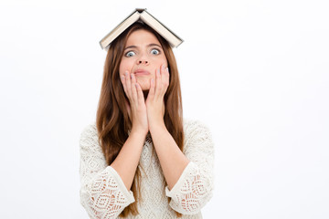Funny astonished cute girl with opened book on her head