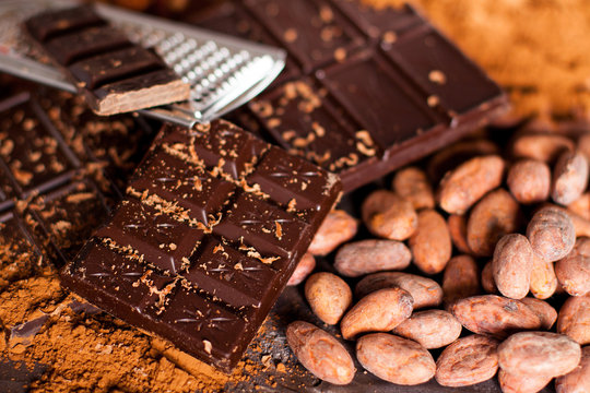 Chocolate products. Chocolate, cocoa beans, cocoa and nuts on wooden background. 