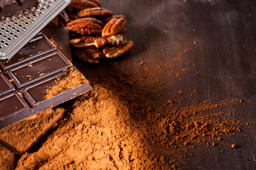 Chocolate products. Chocolate, cocoa beans, cocoa and nuts on wooden background. 