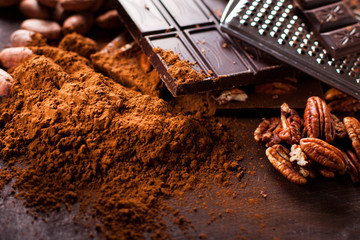 Chocolate products. Chocolate, cocoa beans, cocoa and nuts on wooden background. 