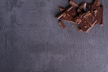 Bitter chocolate on corner, black stone background.