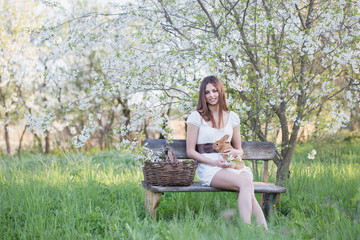 Naklejka na ściany i meble beautiful young woman with rabbits in garden