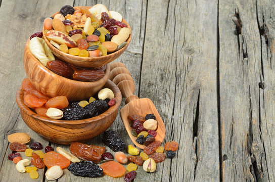 Mix of dried fruits and nuts in a wooden bowl - symbols of judaic holiday Tu Bishvat. Copyspace background.