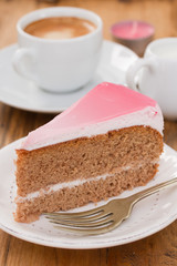 cake on white plate and cup of coffee on brown wooden background