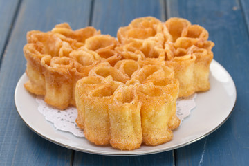 typical portuguese dessert filhos on white plate on blue wooden background