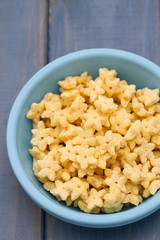 corn flakes in blue plastic bowl on blue wooden background