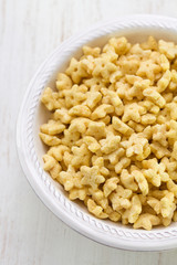 corn flakes in bowl on white wooden background