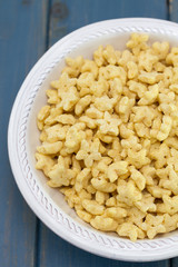 corn flakes in white bowl on blue wooden background