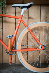 fixed gear bicycle parked with wood wall, close up image