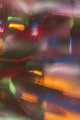 Abstract colorful background. Defocused blurred lights behind a glass surface
