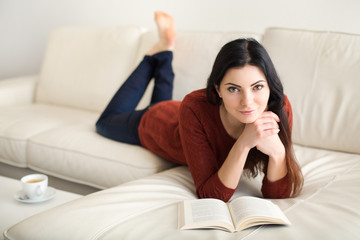 Hübsche Frau beim lesen auf dem Sofa