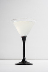 Cocktail in martini glass on the white wooden background
