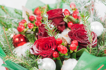 Close-up of Christmas bouquet with flowers and spruce with snow.
