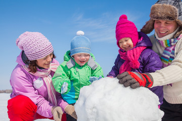 Happy family making snowman