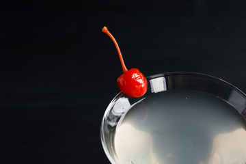 Cocktail in martini glass on the black wooden background