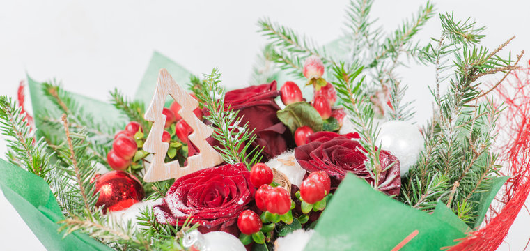 close-up of decorative Christmas tree in a bouquet of red rose,