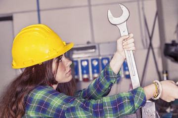 portrait of young female metalworker engaged with wrench