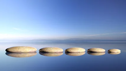 Poster Zen-stenen rij van groot naar klein in water met blauwe lucht en vredige landschapsachtergrond © viperagp