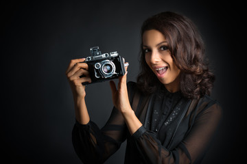 Brunette woman holding  a vintage camera