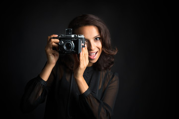 Brunette  beautiful woman taking a photo  with vintage camera