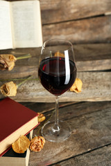 Beautiful composition with glass of wine with old books on table close up