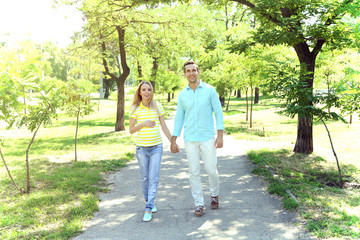 Young pregnant woman with husband walking in park