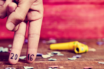 number 2016, as the new year, in the fingers of a young man