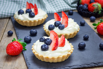 Homemade shortbread tartlets with custard cream, strawberry and blueberry