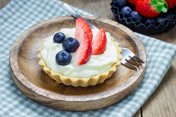 Homemade shortbread tartlets with custard cream, strawberry and blueberry