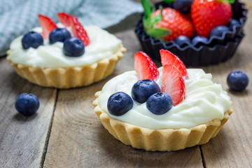 Homemade shortbread tartlets with custard cream, strawberry and blueberry