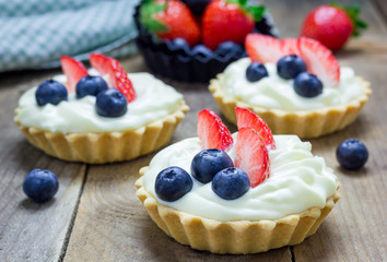 Homemade shortbread tartlets with custard cream, strawberry and blueberry