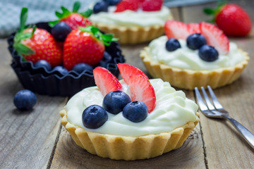 Homemade shortbread tartlets with custard cream, strawberry and blueberry