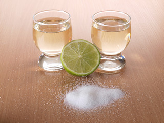 Glass cup with tequila on table