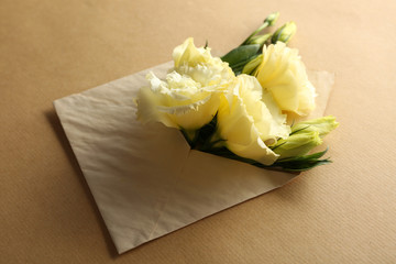 White eustoma in envelope on beige background