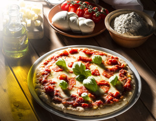 Pizza with tomatoes mozzarella and basil on the wooden table