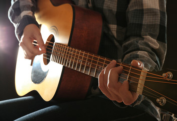Fototapeta na wymiar Close up view on playing guitars in the dark studio