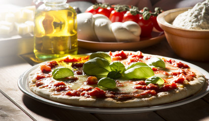 Pizza with tomatoes mozzarella and basil on the wooden table