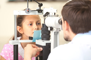 Adult male doctor examing small girl patient