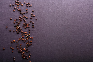 Roasted coffee beans on grey textile background