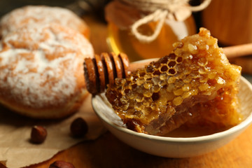Honeycombs on plate, hot buns on wooden background