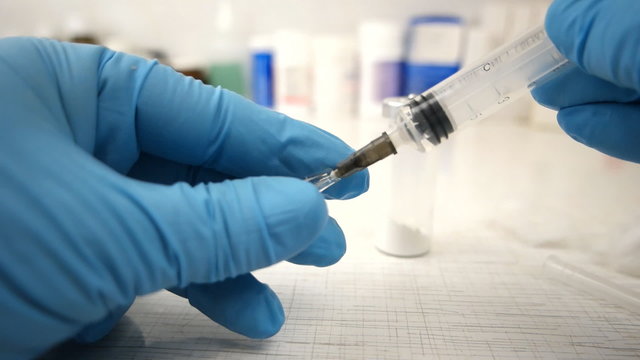 Female doctorFemale doctor carefully preparing an injection