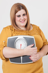 Overweight woman holding a bathroom scale